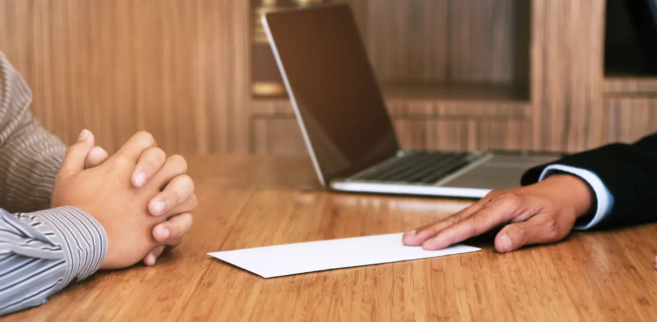 patrão entregando carta de demissão para funcionário